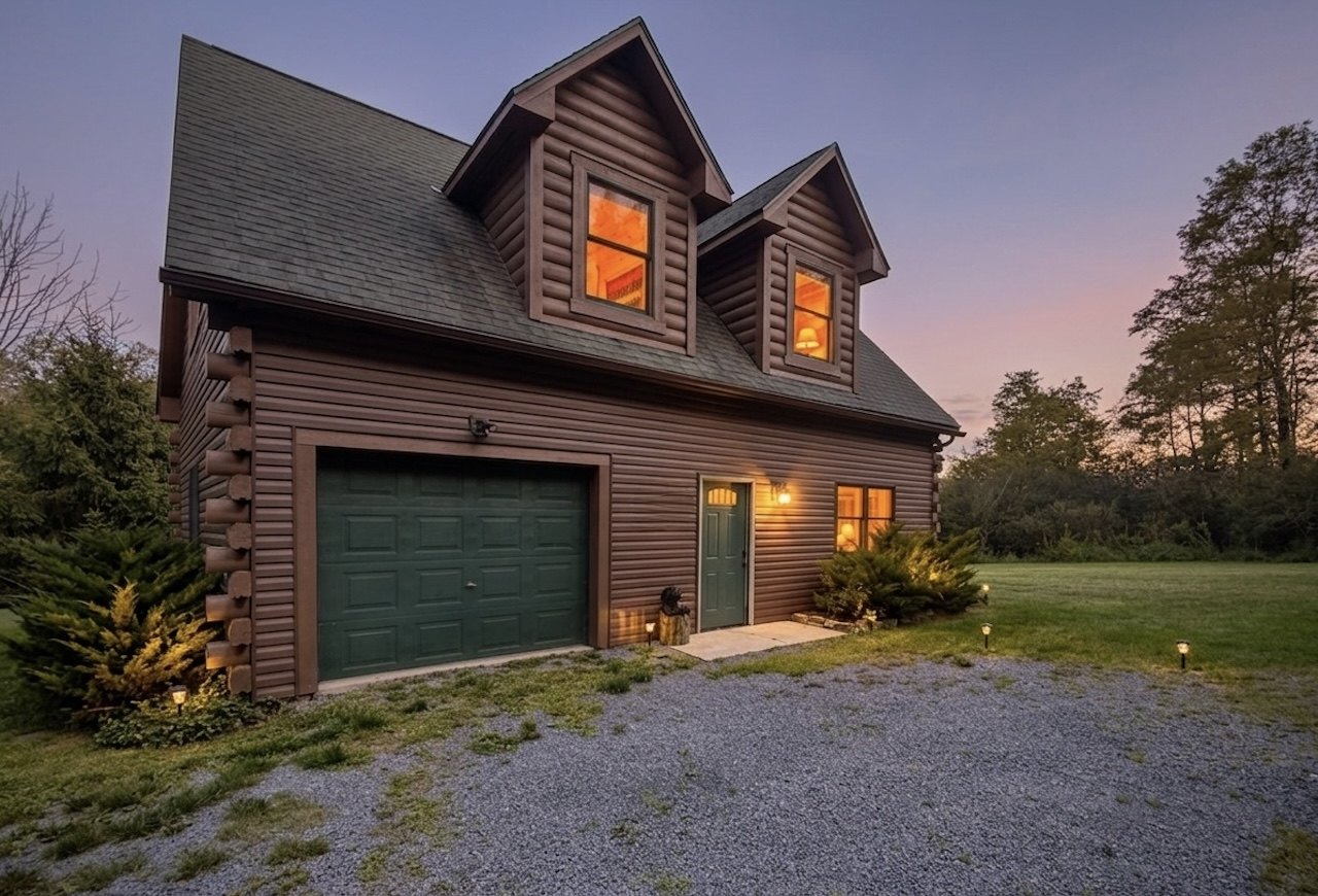 Fernwood Escape log cabin glowing at dusk, with warm windows and a lit path